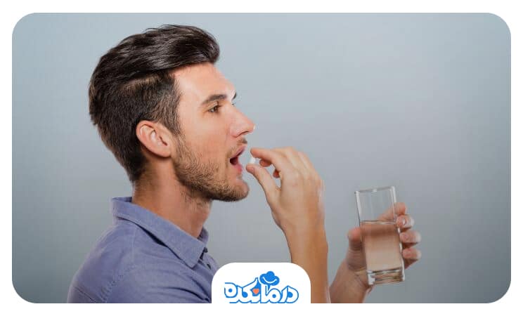 مردی که در حال خوردن دارو است و یک لیوان آب در دست دارد