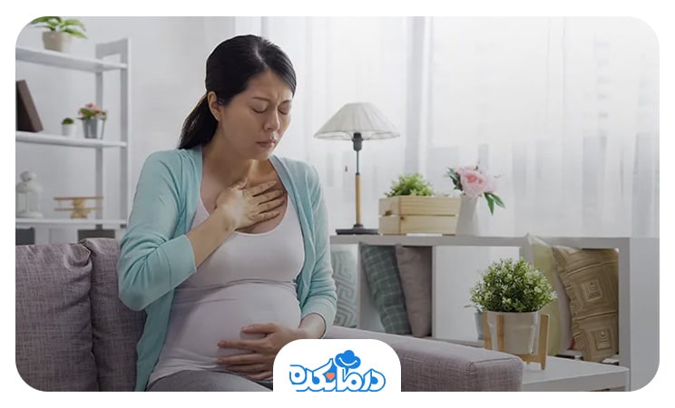 زنان باردار مبتلا به رفلاکس معده که یک دست خود را روی شکم و دست دیگر را روی قفسه سینه گذاشته است
