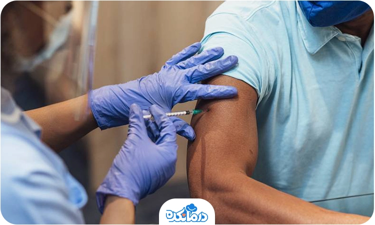 یکی از پرسنل بهداشتی به بازوی یک مرد واکسن  تزریق می‌کند 